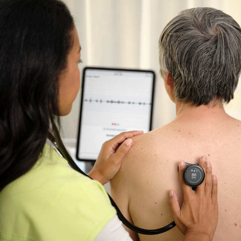 Nurse listens to patient's lung sounds with digital stethoscope