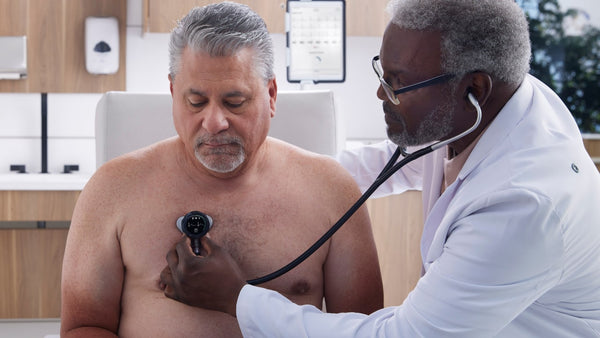 Doctor listens to older male patient using digital stethoscope