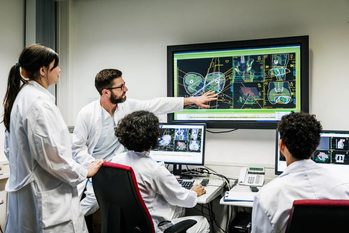 Clinicians looking a AI outputs on wall monitor