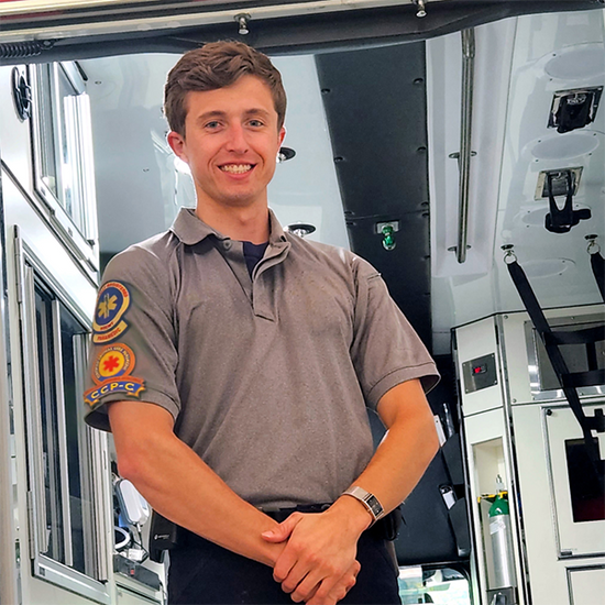 Paramedic Hunter Burnette poses in front of ambulance