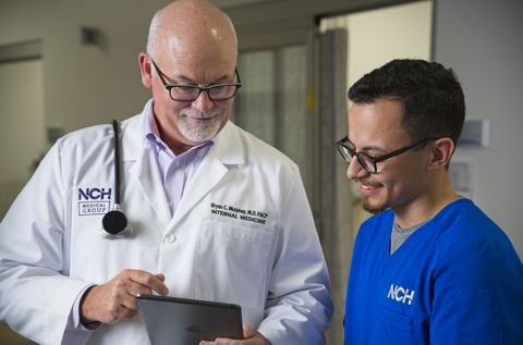 Physician shows information on iPad to nurse in a hospital